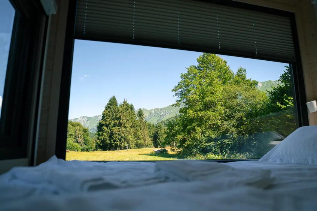 Letto matrimoniale interno a Friland Abete con vista panoramica sul bosco